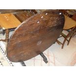 A continental oval oak tilt top Vintners table on trestle base