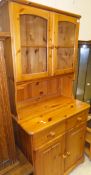 A modern pine dresser, the glazed top above two drawers and two cupboard doors,