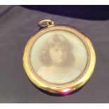 A circa 1900 9 carat gold cased pendant housing two miniatures of young girls CONDITION