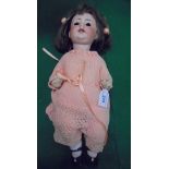 An early 20th Century German bisque-headed doll with bent limb composition body,