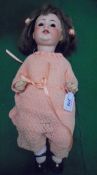 An early 20th Century German bisque-headed doll with bent limb composition body,