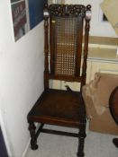 A hall chair in the Carolean manner with caned back above a solid seat,