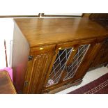 An Old Charm style suite comprising dining table and four chairs, dresser and drinks' cabinet,