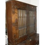 An oak cabinet with applied decorative ironwork,