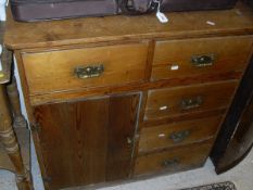 A pine unit of five assorted drawers and a single cupboard door to plinth base