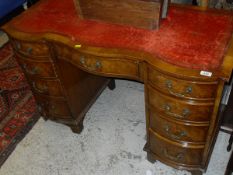 A modern reproduction figured walnut shaped front desk with central serpentine drawer flanked by