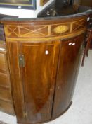 A 19th Century mahogany bow fronted two door wall hanging corner cupboard with decorative inlay and