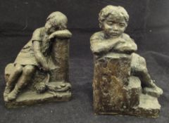 A pair of 20th Century cold cast bronze figural bookends as children leaning upon steps and bearing