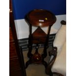 A mahogany wash-stand with circular turned top on three supports with two drawers united under tier