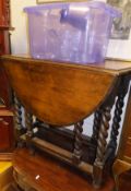 An oak drop-leaf table with barley-twist supports and stretchered base,