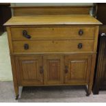 An early 20th century oak chest with two drawers, cupboards to the base,