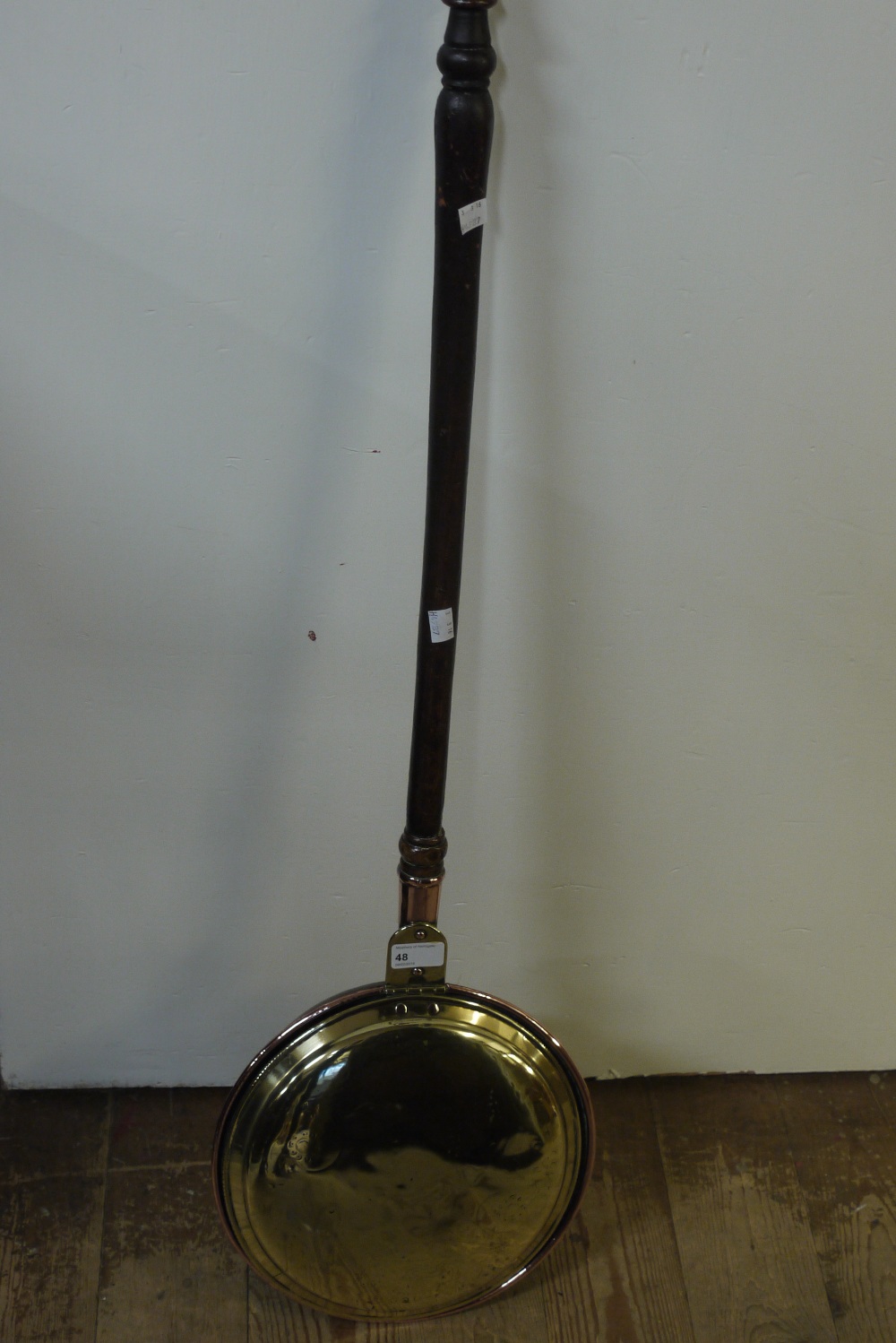 A copper and brass bed warming pan with turned stained beech handle