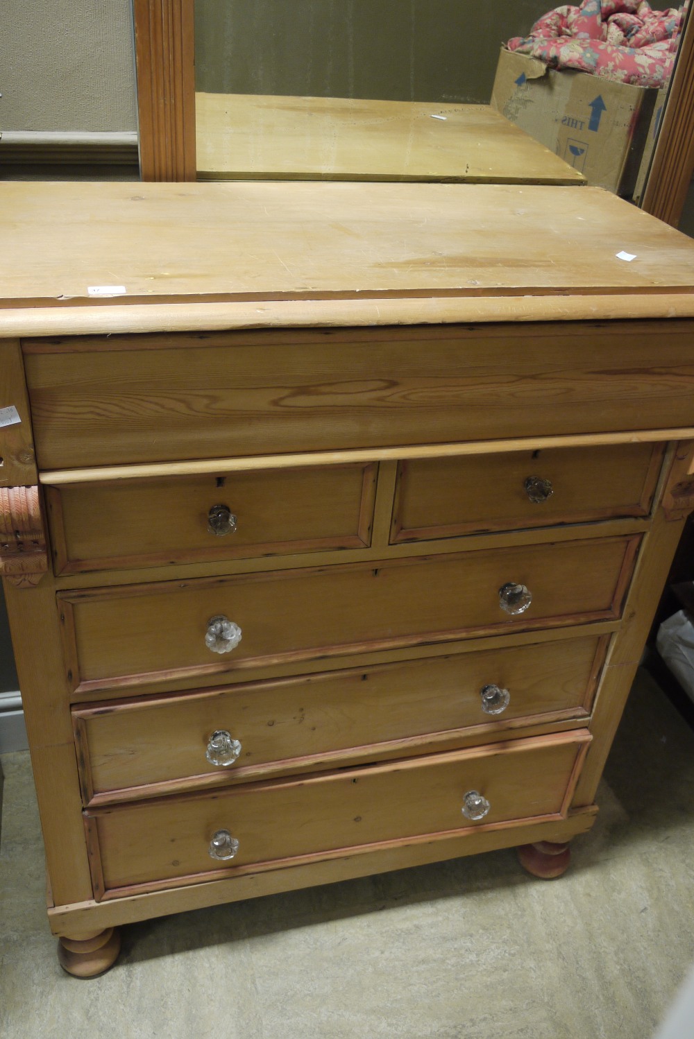 A Victorian pine chest of drawers with shaped frieze drawer,