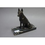 A bronze figure of a seated German Shepherd dog on marble base