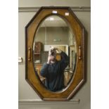 An oak framed oval wall mirror with moulded frame