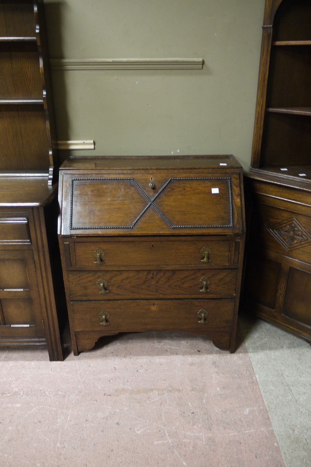A 20th century oak bureau desk with slope fall front, interior with single drawer and pigeon holes,