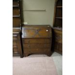 A 20th century oak bureau desk with slope fall front, interior with single drawer and pigeon holes,