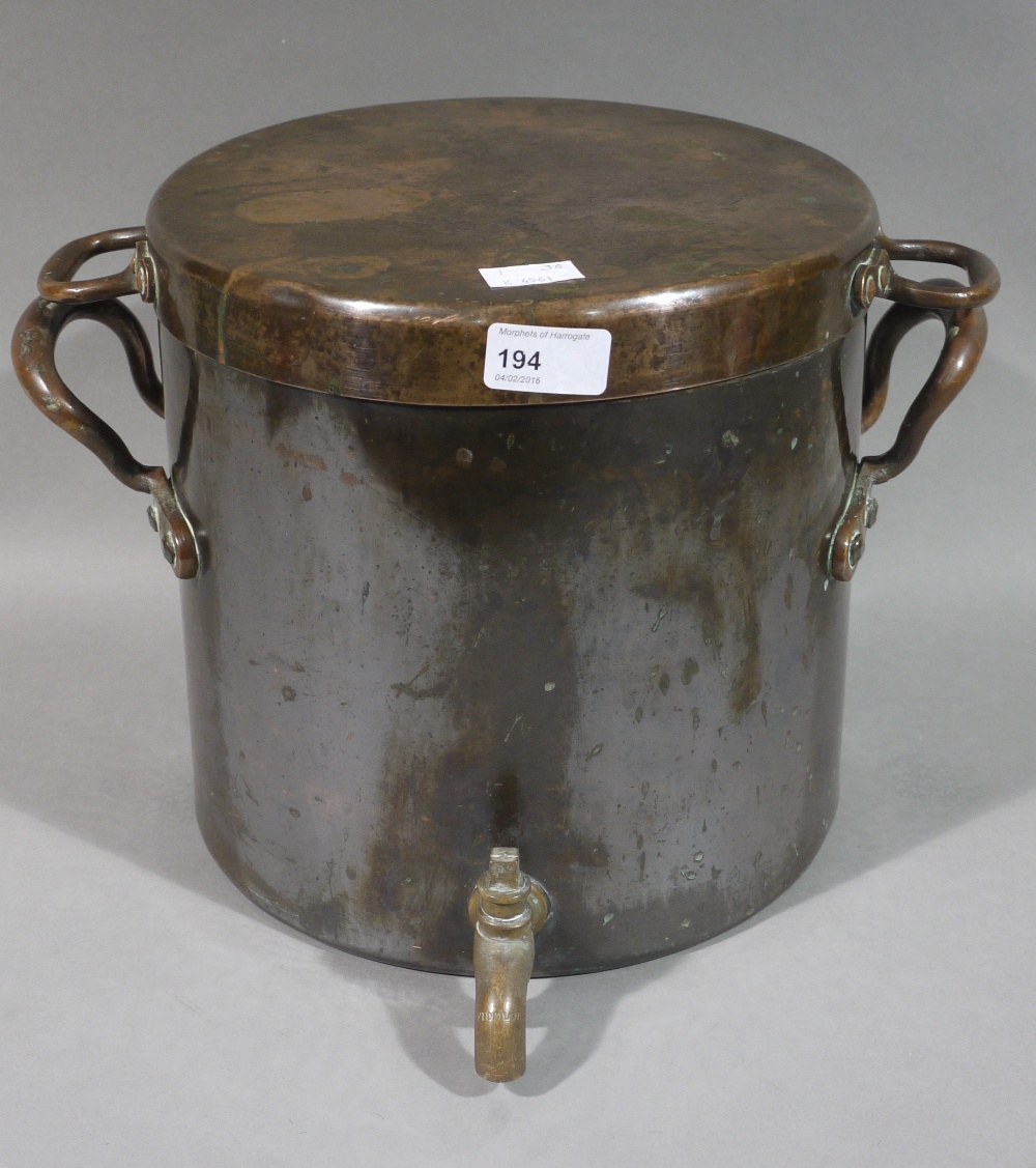 A copper cistern and cover with brass spigot