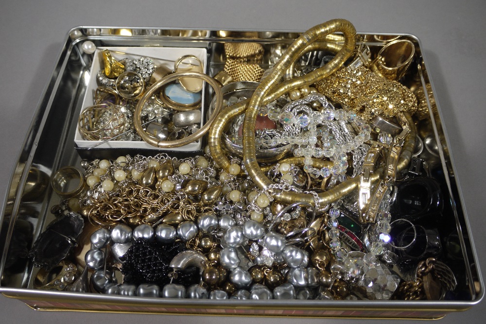 A tin of mixed costume jewellery