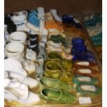 A tray of 19th and early 20th century model ceramic and glass shoes including pressed glass boots,