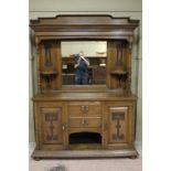 An early 20th century Arts and Crafts mirror backed dresser with arched raised top,