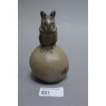 A Poole Pottery stoneware figure of a mouse seated on an apple