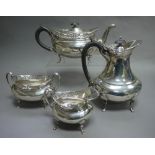 A four piece silver tea service of oval outline with pierced everted rims, and on paw feet,