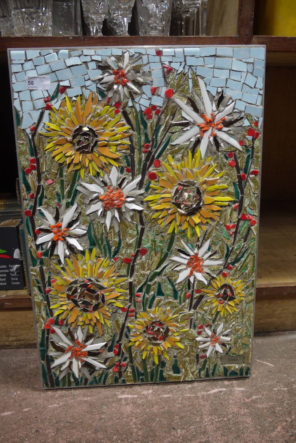 Estdale, a ceramic mosaic of growing flowers under a blue sky within a steel frame,