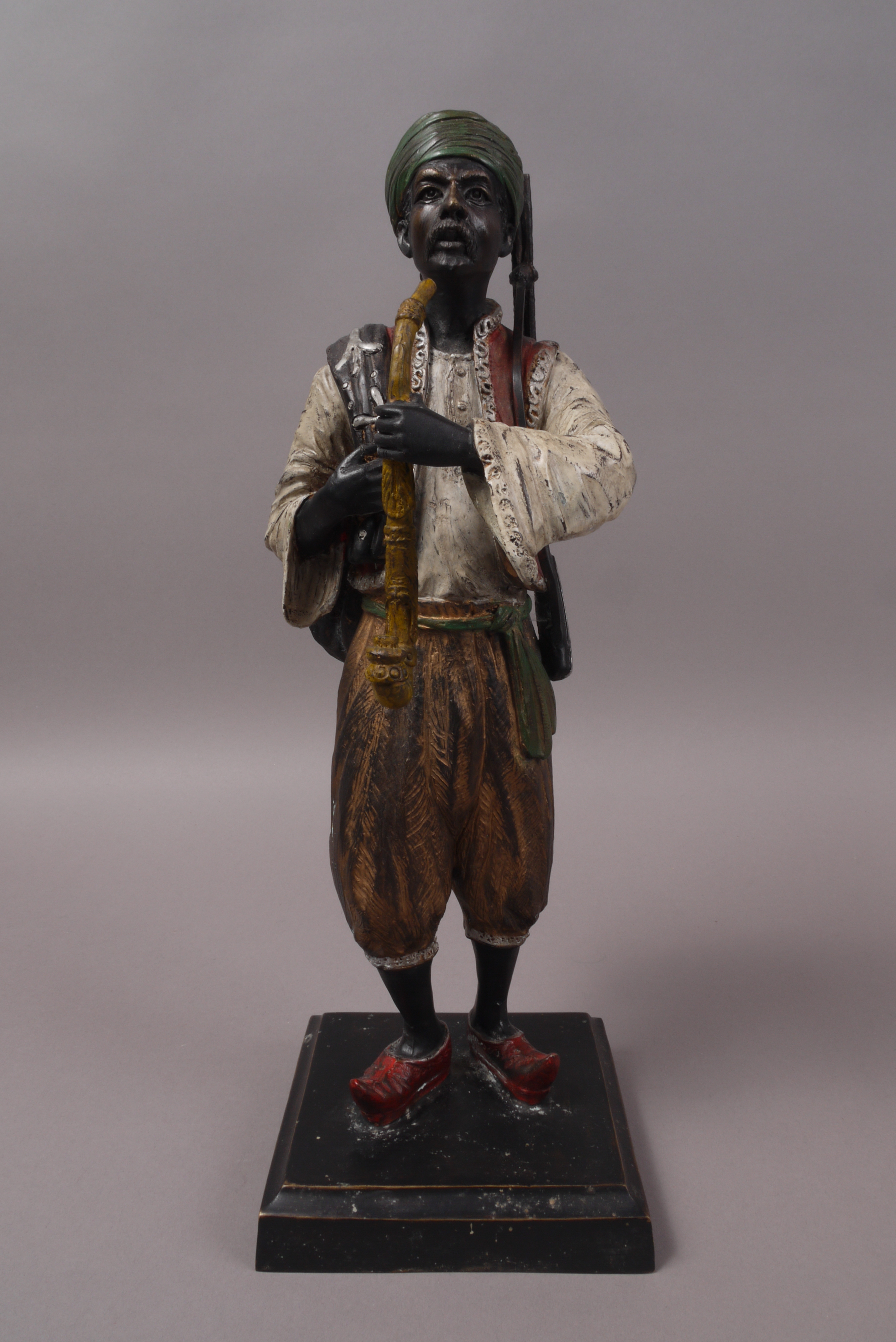 A CONTINENTAL COLD PAINTED BRONZE FIGURE of an Arab in traditional costume,
