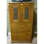 A carved pollard oak tall boy with double carved panel doors above four graduated drawers on