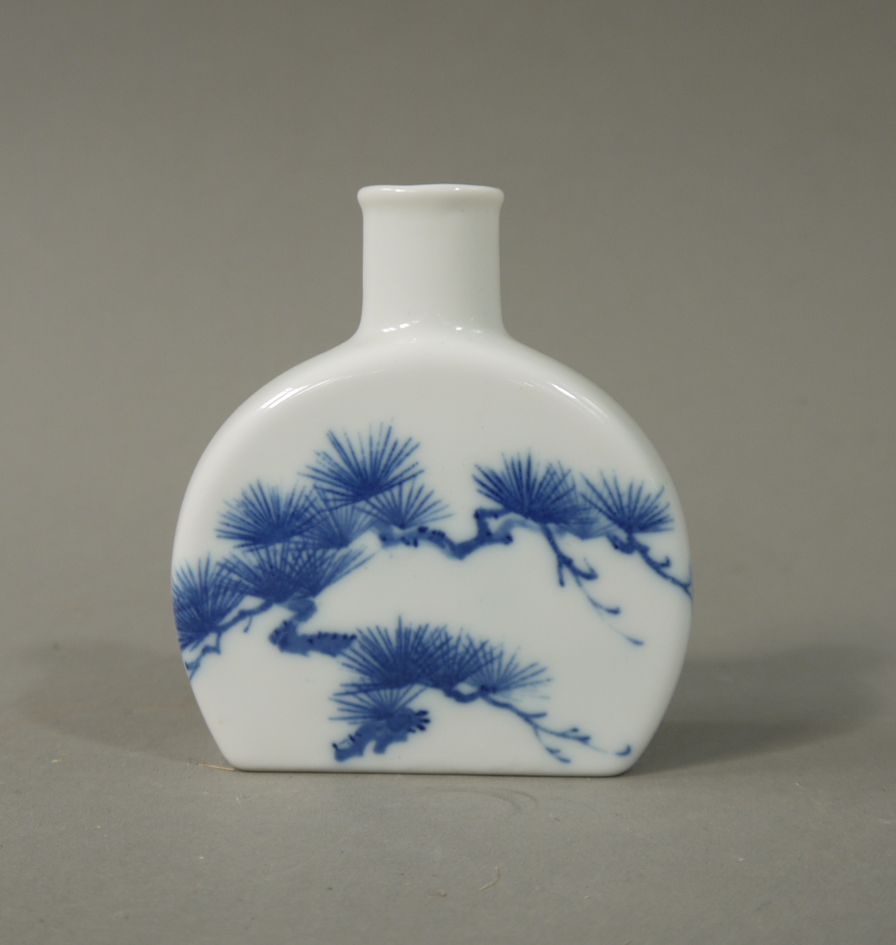 A Chinese semi-circular flask, 20th century, decorated in underglaze blue with pine branches, 9.