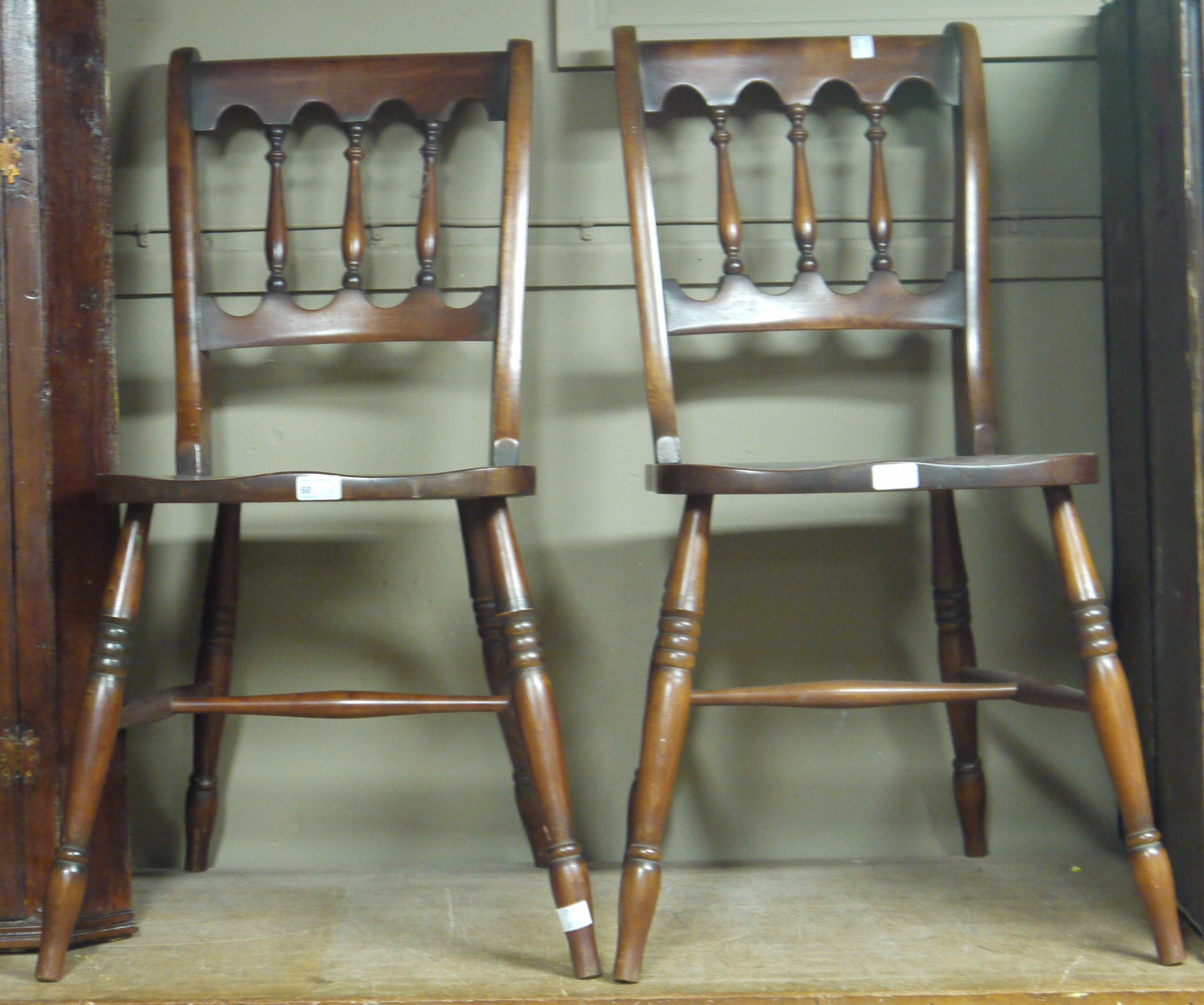 A pair of stained beech lathe back kitchen chairs