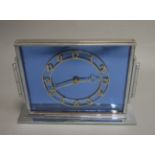 An Art Deco chromed metal angular spring driven mantel clock, with circular cut brass dial,