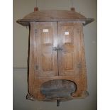 An Oriental elm wall hanging cupboard with broad shaped back plate and double panelled doors and