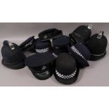 Three police hard helmets; a Leeds City Police cap; another; four Policewomen's hats,