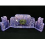 An Art Deco Period Three Piece Purple Lustre Glazed Clock Garniture Set