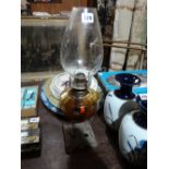 A Square Metallic Based Oil Lamp With Glass Reservoir