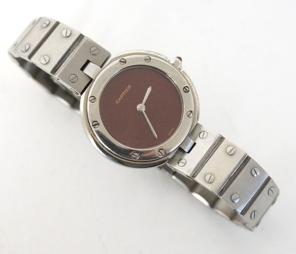 LADY'S CARTIER STAINLESS STEEL WRISTWATCH  
with a circular claret coloured dial and quartz