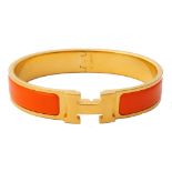 HERMES 'CLIC H' ORANGE ENAMEL DECORATED GOLD PLATED BRACELET with central 'H' motif,