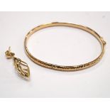 NINE CARAT GOLD OVAL BANGLE with clip fitment, approximately 4.