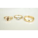 THREE NINE CARAT GOLD RINGS comprising a wedding band, size S-T; a CZ set single stone ring,