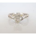 DIAMOND SOLITAIRE RING the central heart shaped diamond flanked by further channel set diamonds to