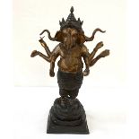 INDIAN BRONZE FIGURE OF A THREE HEADED GANESH standing within a coiled cobra to his feet and with a