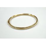 NINE CARAT GOLD BANGLE with safety clasp,
