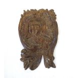 18th CENTURY CARVED WOODEN WALL PLAQUE depicting a religious figure within a floral scroll surround,