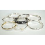 SELECTION OF EIGHT SILVER BANGLES of various designs, including a CZ set silver gilt example,