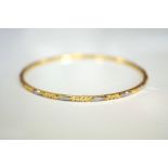 UNMARKED HIGH CARAT GOLD BANGLE with engraved decoration, approximately 9.