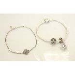 TWO SILVER PANDORA BRACELETS one a charm bracelet with two charms;