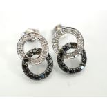 PAIR OF BLACK AND WHITE DIAMOND EARRINGS of entwined circle design, in nine carat white gold,