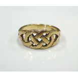 NINE CARAT GOLD RING with pierced Celtic knot decoration, ring size P-Q,